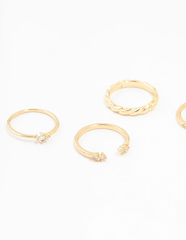 Showcasing gold plated dainty diamante rings in a 5-pack with textured and embellished bands close up view
