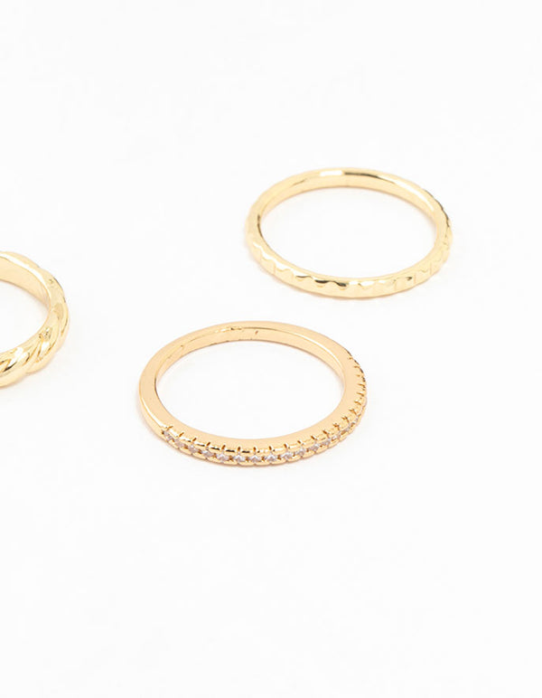 Showcasing gold plated dainty diamante rings in a 5-pack with textured and embellished bands close up view