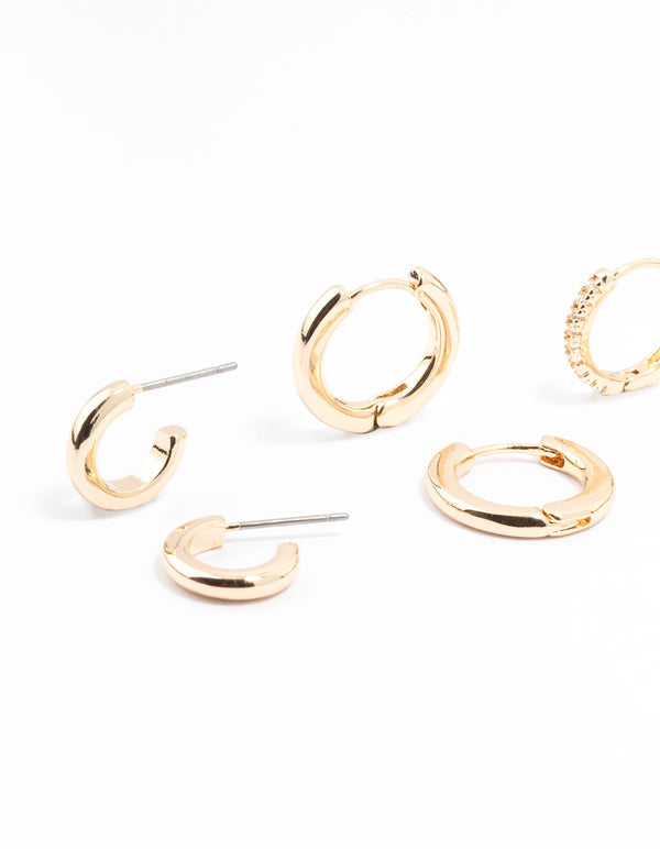 Showcasing gold minimal huggie hoop earrings in a stackable 3-pack close up view