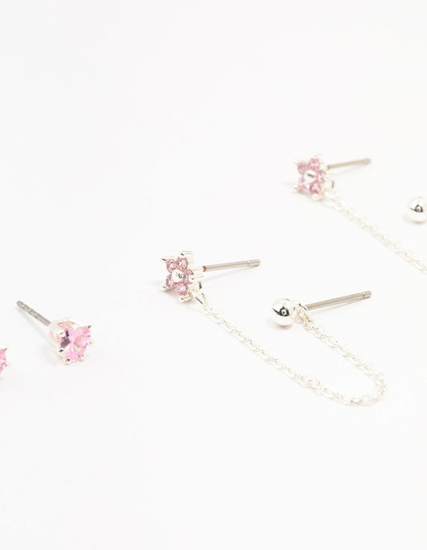 Crafted from silver plated brass, these heart flower chain earrings in a 3-pack showcase floral charm details with pink accents close up view