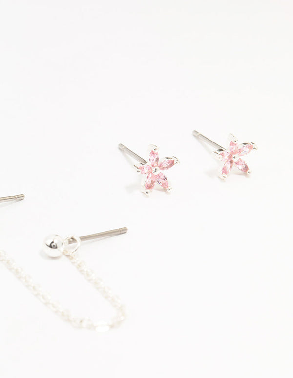 Crafted from silver plated brass, these heart flower chain earrings in a 3-pack showcase floral charm details with pink accents close up view