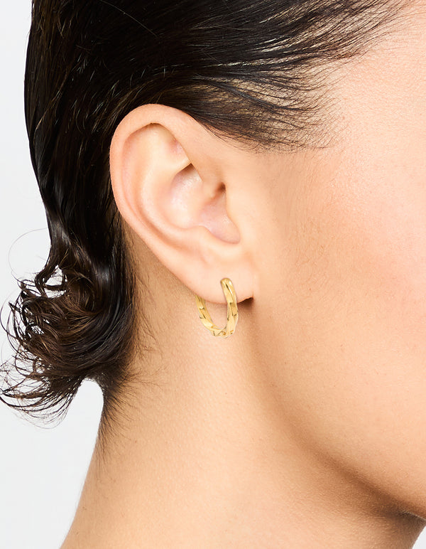 Showcasing waterproof gold plated stainless steel twisted hoop earrings on ear view
