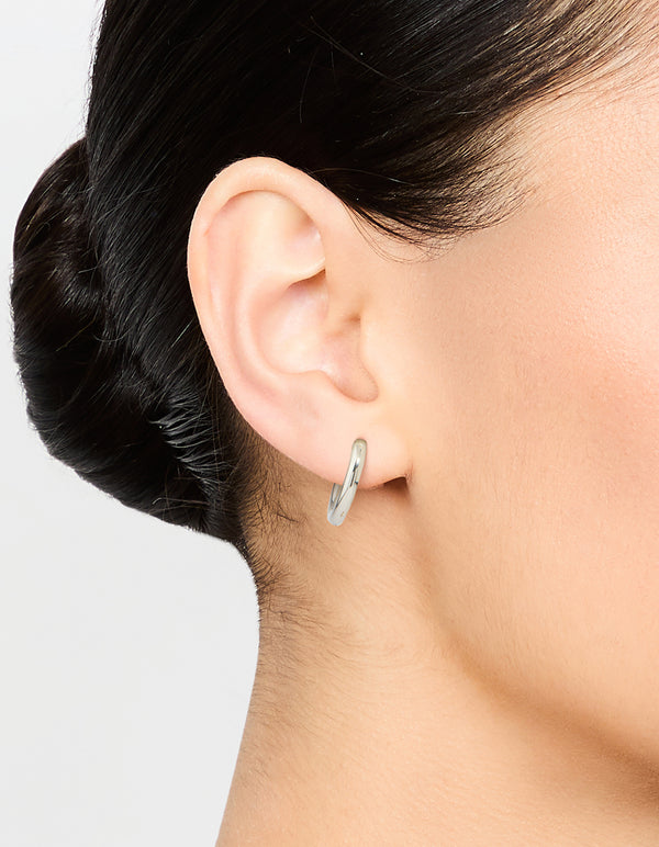 Featuring waterproof stainless steel core clicker earrings in 14mm chunky style with huggie closure and silver color on ear view