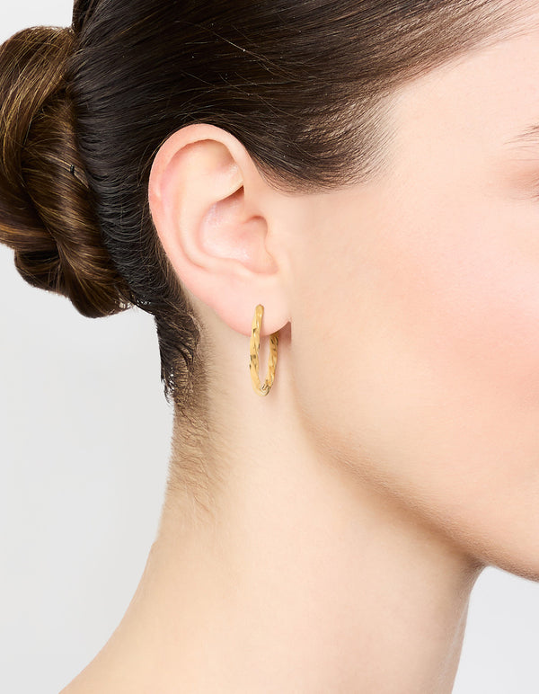 Showcasing waterproof twisted hoop earrings crafted from gold plated stainless steel on ear view