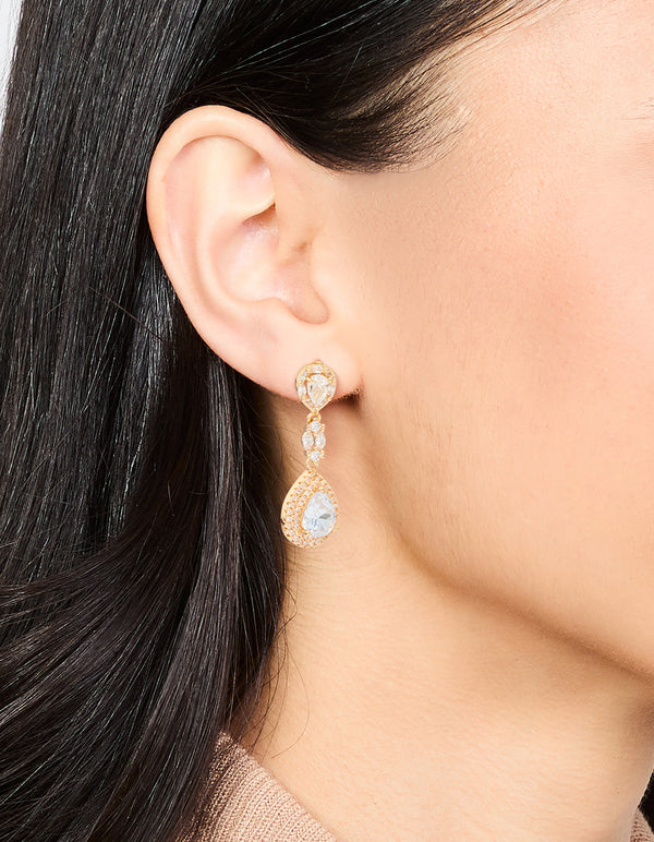 Featuring gold cubic zirconia halo pear drop earrings with clear accents on ear view