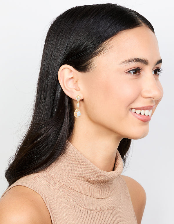Highlighting gold cubic zirconia halo pear drop earrings with clear accents on model view