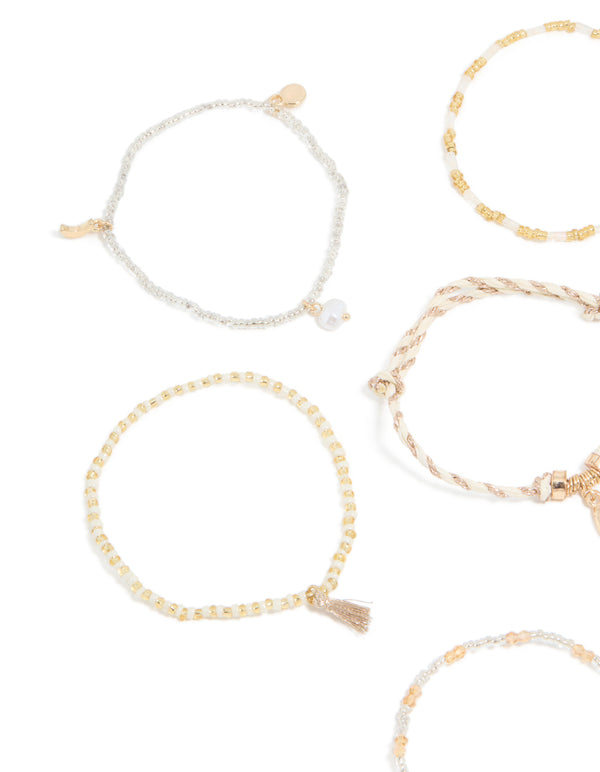 Featuring gold beaded pearl beachy bracelets 7-pack with ocean-inspired tassel charms close up view