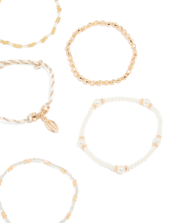 Highlighting gold beaded pearl beachy bracelets 7-pack with ocean tassel charms detail view