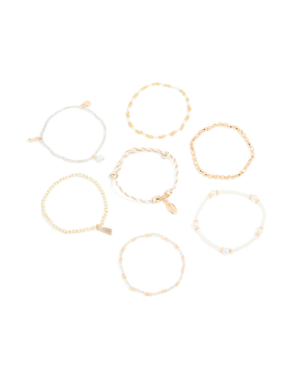 Showcasing gold beaded pearl beachy bracelets 7-pack featuring ocean-inspired charms with tassels front view