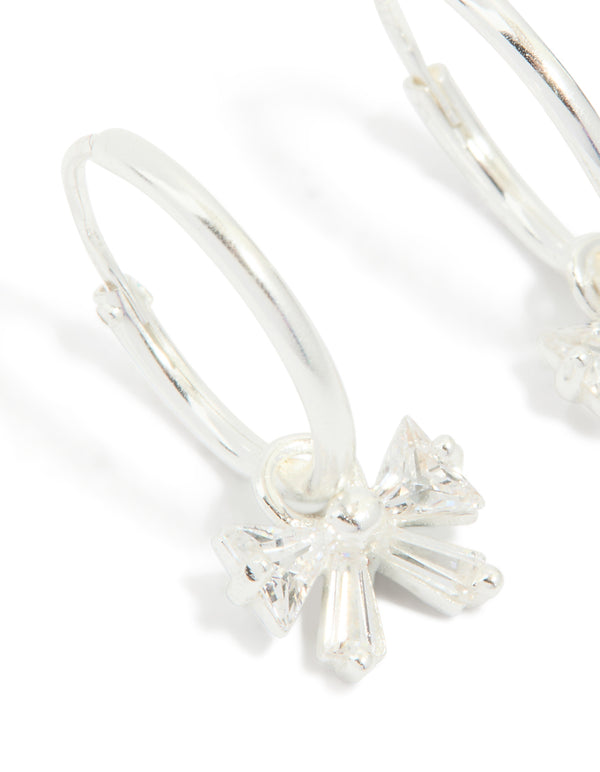 Detailed sterling silver cubic zirconia bow huggie earrings close up view