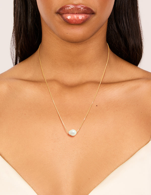 Showcasing a gold plated freshwater pearl dainty snake chain necklace on neck view
