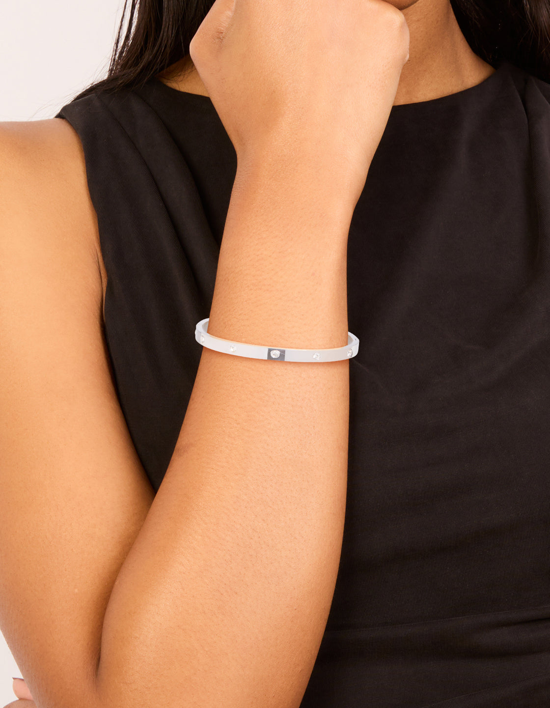 Showcasing a waterproof stainless steel diamante hinged bangle in silver on wrist view