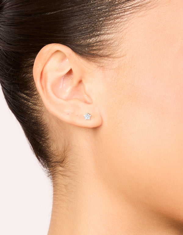 Featuring celestial waterproof stainless steel prism cubic zirconia star stud earrings in 4 MM silver and clear on ear view