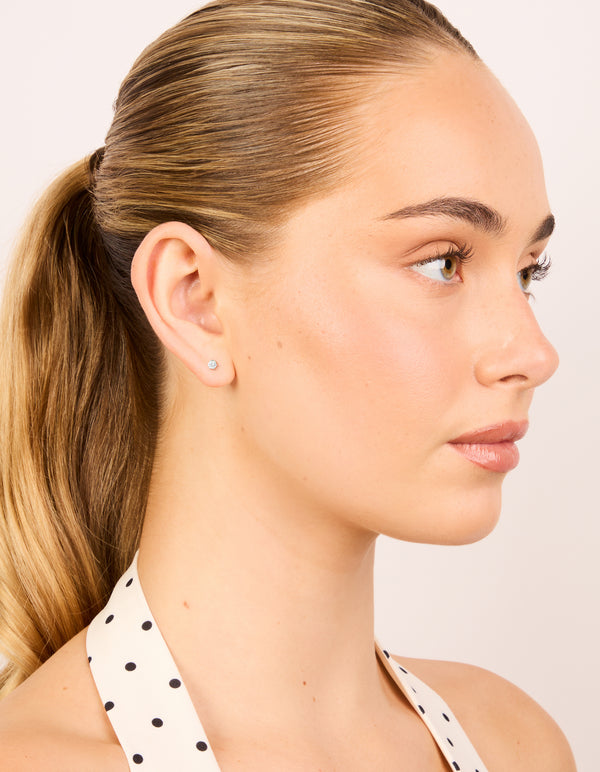 Crafted from waterproof stainless steel with cubic zirconia prism stud earrings in silver and clear on model view