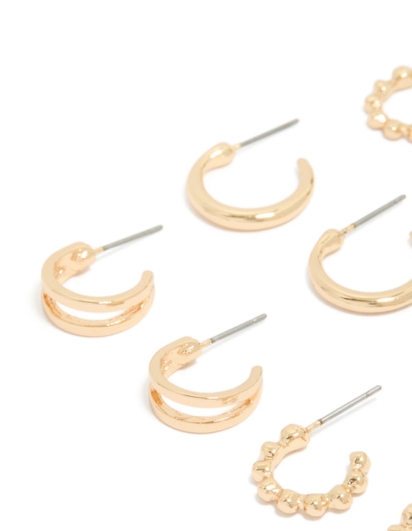 Featuring dainty hoop earrings in a 6-pack set in gold finish close up view
