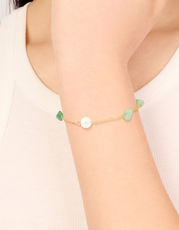 Showcasing a waterproof gold-plated stainless steel bracelet with pearl beads and green semi precious stone chips on wrist view