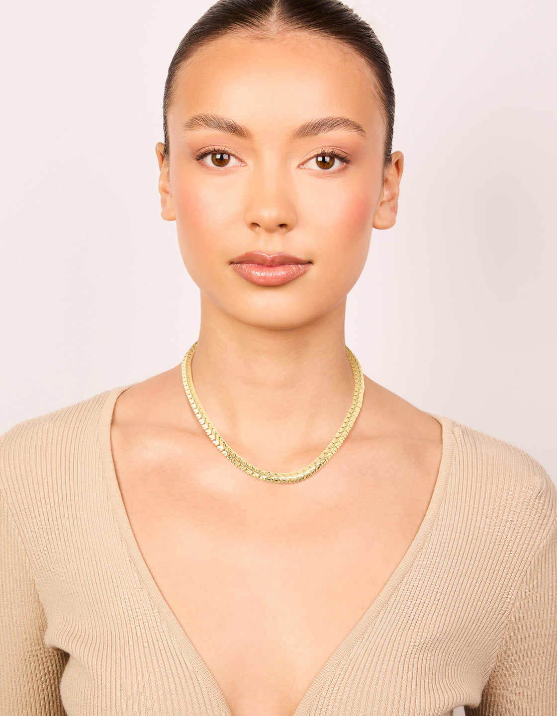 Showcasing a waterproof interlock chain necklace made from gold plated stainless steel featuring statement styling on model view
