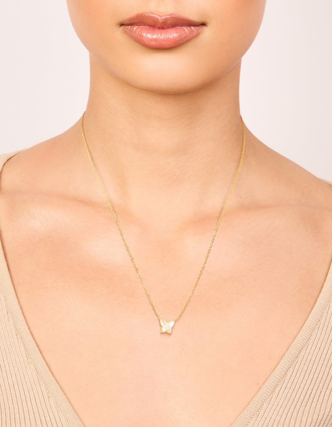 Showcasing a waterproof butterfly pendant necklace crafted from gold plated stainless steel with cubic zirconia on neck view