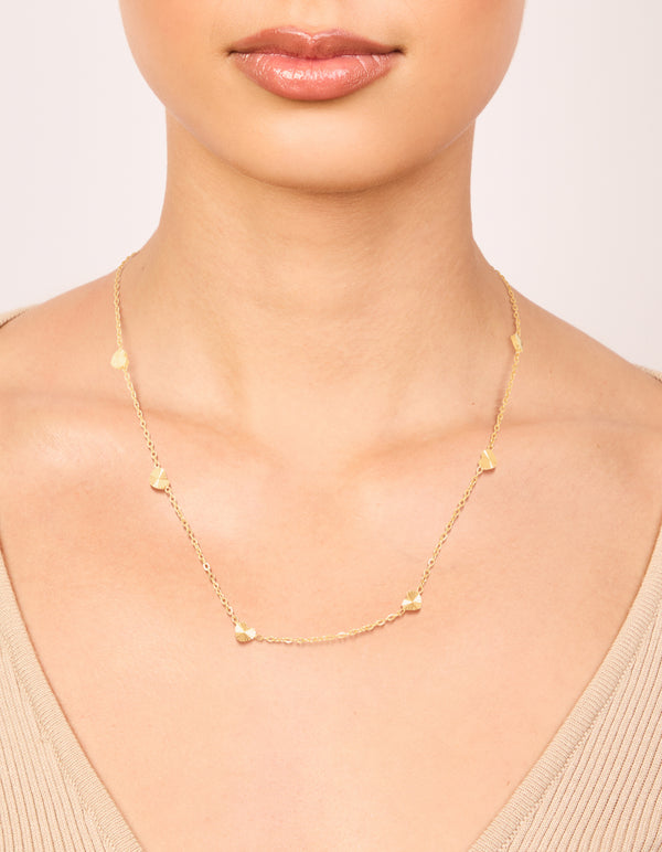 Delicate waterproof micro hearts necklace in gold plated stainless steel featuring dainty styling on neck view
