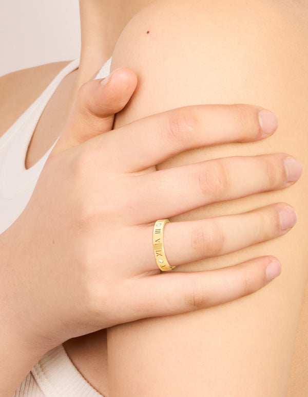 Showcasing waterproof gold plated stainless steel band ring with roman numerals and cubic zirconia on finger view