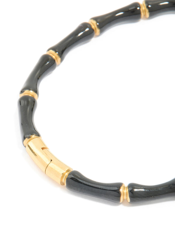 Crafted from waterproof gold plated stainless steel featuring black enamel bamboo bangle with statement styling closure detail view