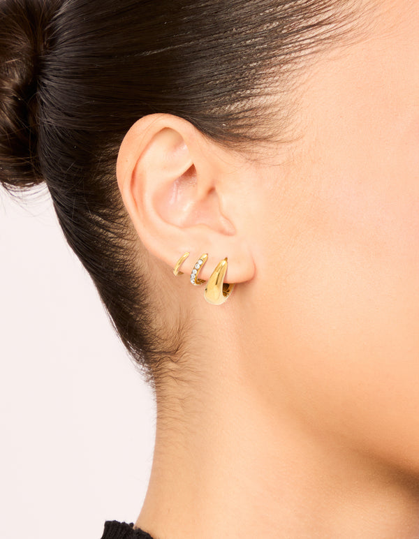 Showcasing waterproof gold plated stainless steel cubic zirconia mix huggie earrings in a 3-pack on ear view