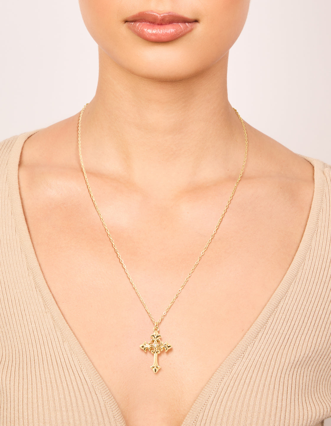 Showcasing a waterproof gold plated stainless steel gothic cross necklace in dainty style on neck view