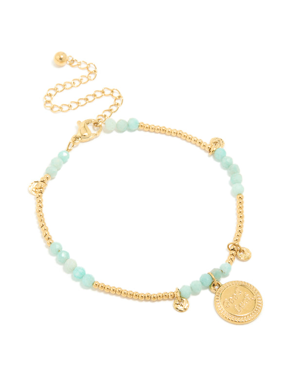 Featuring a waterproof beaded bracelet crafted from gold plated stainless steel, featuring aquamarine beads and script charms in a dainty style in a front view