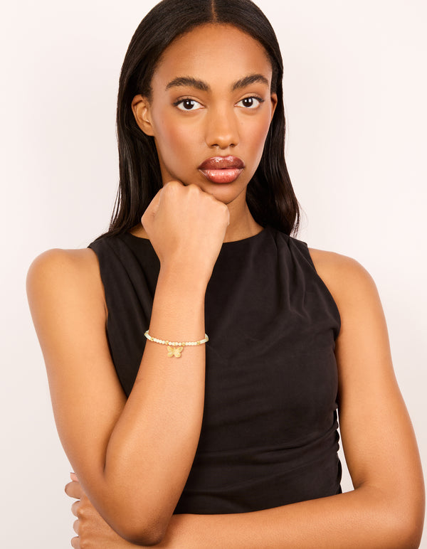 Featuring a waterproof gold plated stainless steel green semi precious stone butterfly stretch bracelet with beads on model view