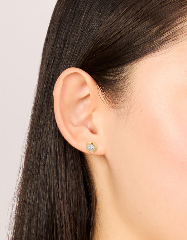 Showcasing waterproof gold plated stainless steel cubic zirconia bezel stud earrings with round stone cut on ear view