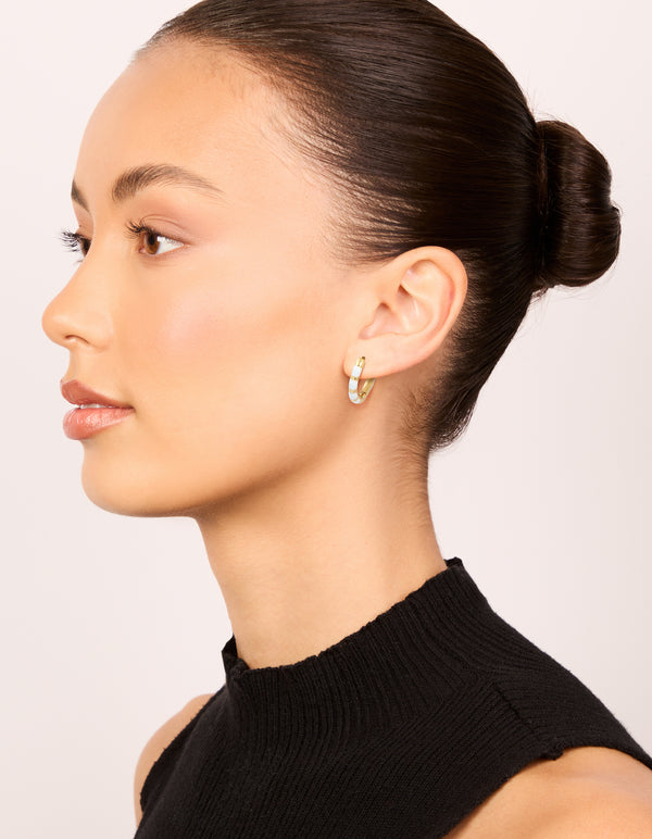 Featuring waterproof gold plated stainless steel white enamel bamboo huggie earrings on model view