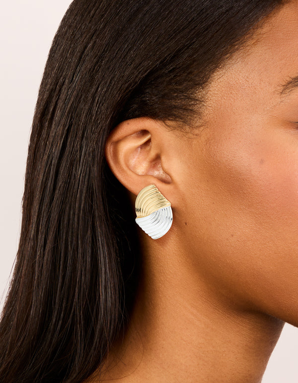 Showcasing mixed metal plated wavy ribbed stud earrings crafted from gold and silver on ear view