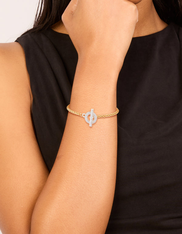 Showcasing a mixed metal silver plated T and O chain bracelet with gold plated links and cubic zirconia toggle closure on wrist view