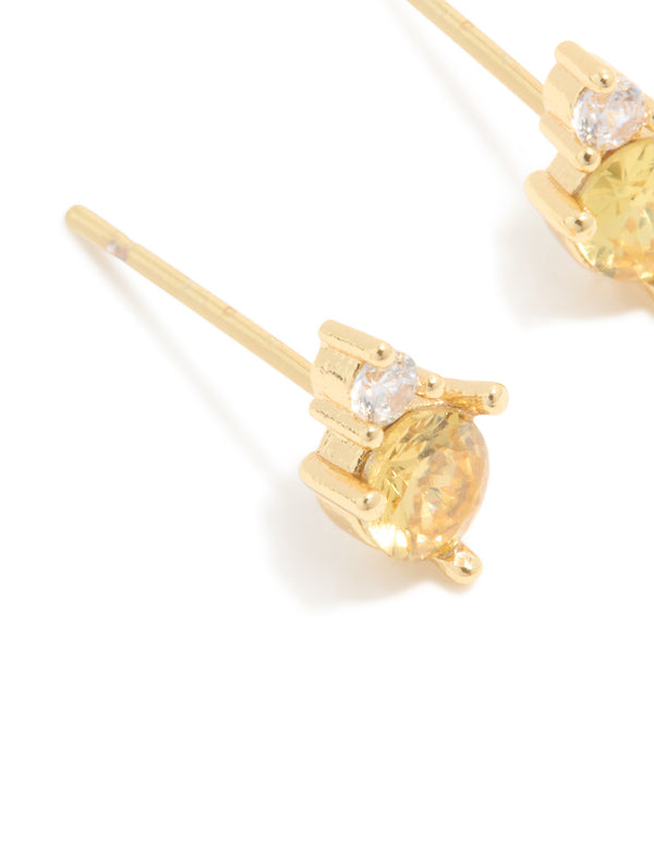 Showcasing waterproof stainless steel November cubic zirconia duo stud earrings in gold with yellow and clear stones close up view