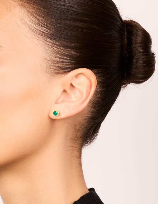 Showcasing dainty waterproof stainless steel bezel stud earrings with emerald round cut cubic zirconia in gold plated teal on ear view