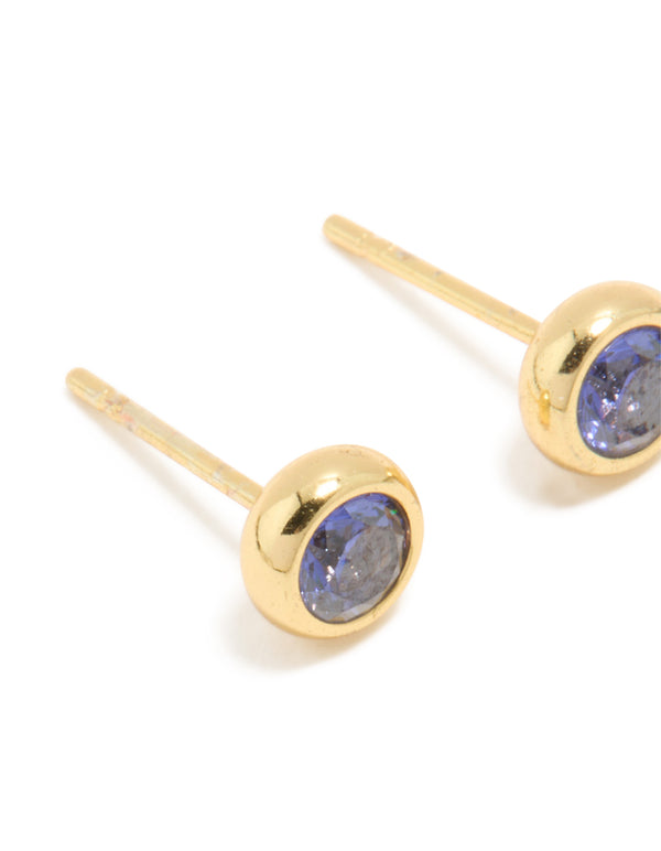 Designed with waterproof gold plated stainless steel, these tanzanite cubic zirconia December birthstone bezel earrings feature round cut stones and stud closure in royal blue close up view