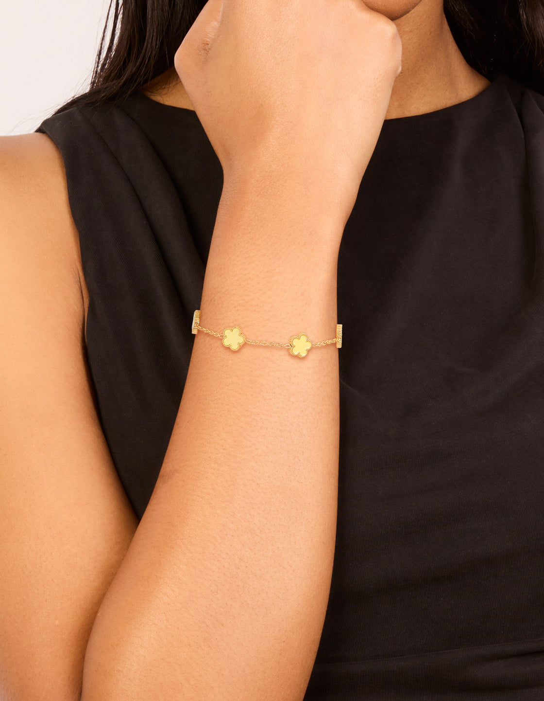Showcasing a waterproof gold plated stainless steel butter yellow flowers charm bracelet in a dainty style on wrist view