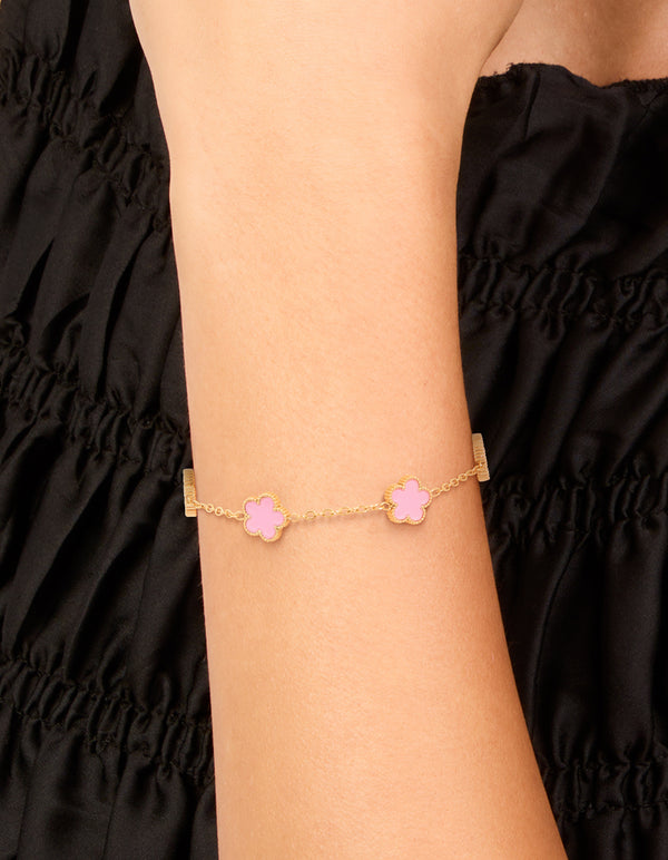 Dainty waterproof gold plated stainless steel charm bracelet featuring light pink petal flower on wrist view