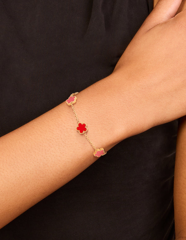 Featuring a waterproof gold plated stainless steel red shell petal flower charm bracelet on wrist view