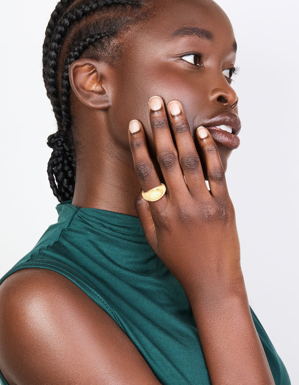 Featuring a gold plated ring with pale green oval stone in a statement style on finger view