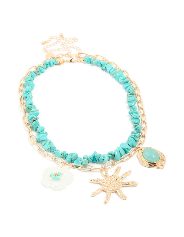 Beautifully crafted layered necklace featuring beaded turquoise, charm, floral accents, and ocean-inspired in gold front view