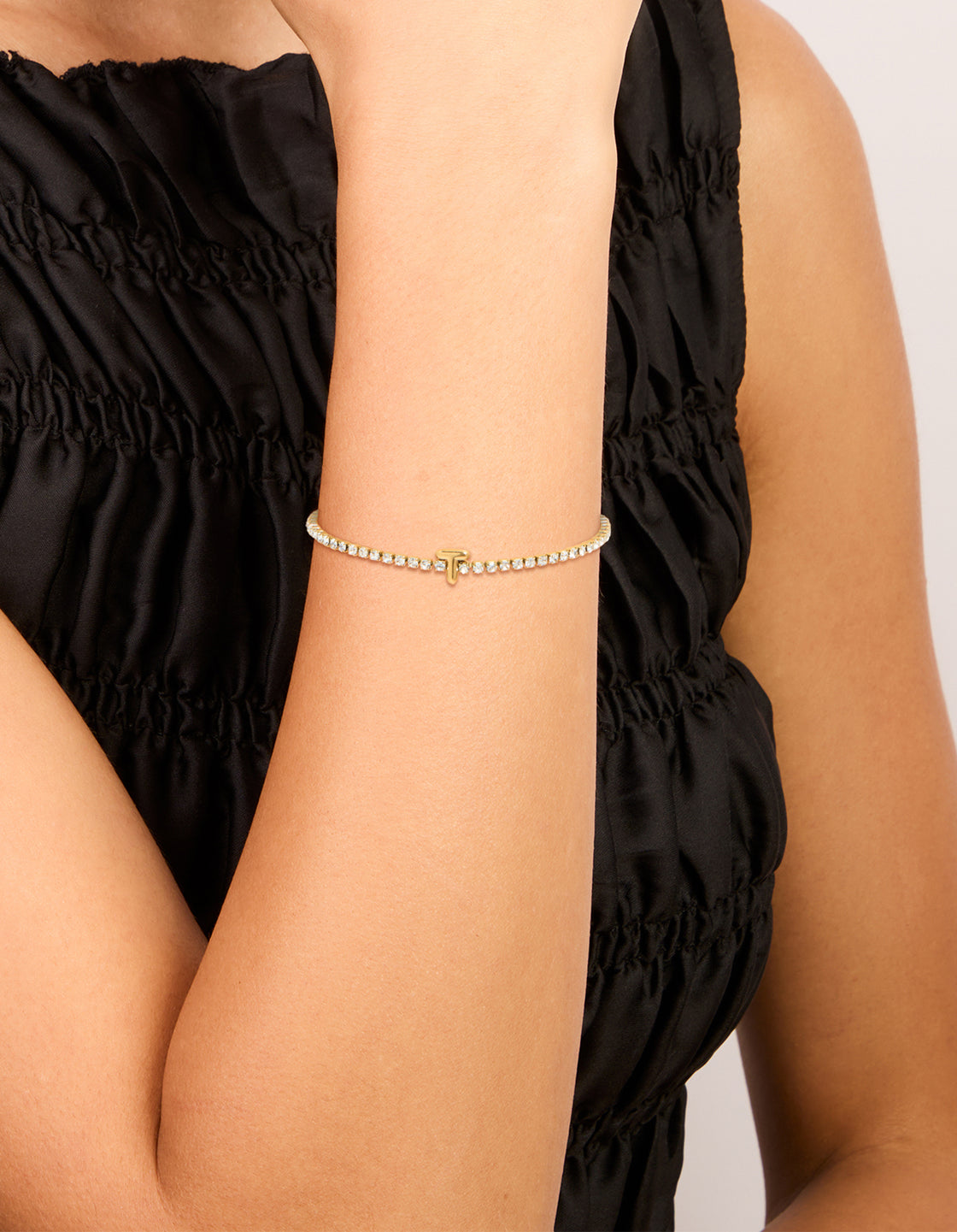 Showcasing a waterproof gold plated stainless steel cubic zirconia letter T initial tennis bracelet on wrist view