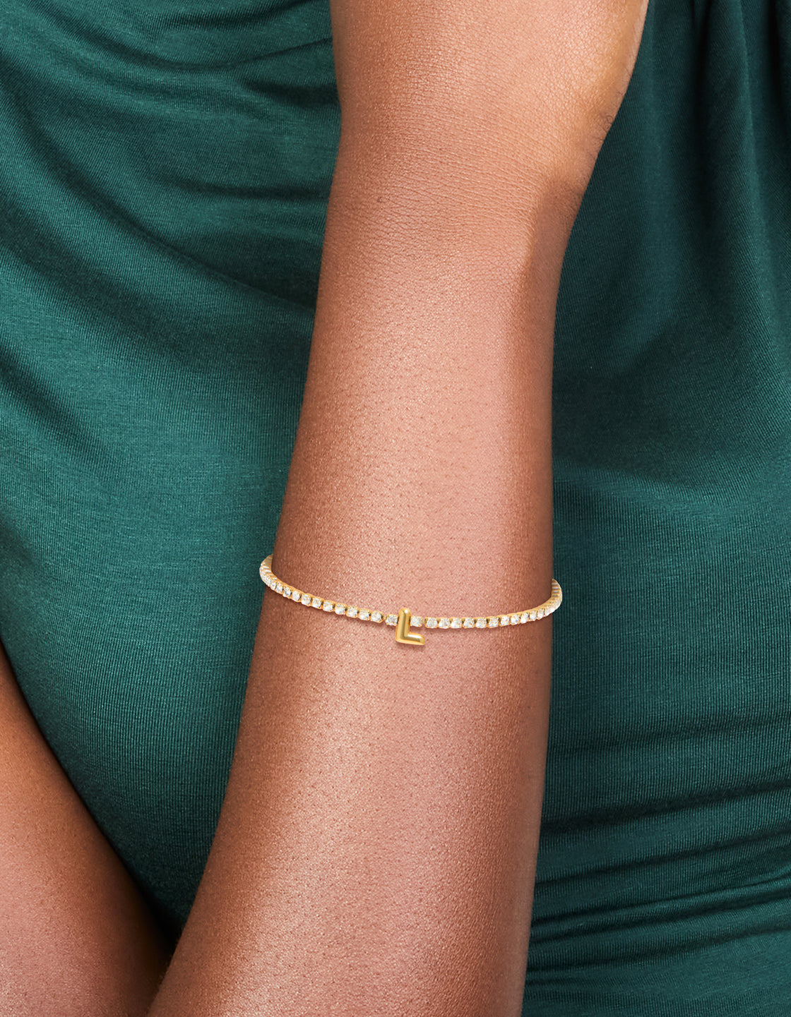 Showcasing a waterproof gold plated stainless steel cubic zirconia tennis letter L bracelet with initials in dainty statement style on wrist view