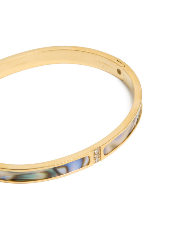 Designed with waterproof gold plated stainless steel and blue green pearlised inlay hinged bangle in close up view