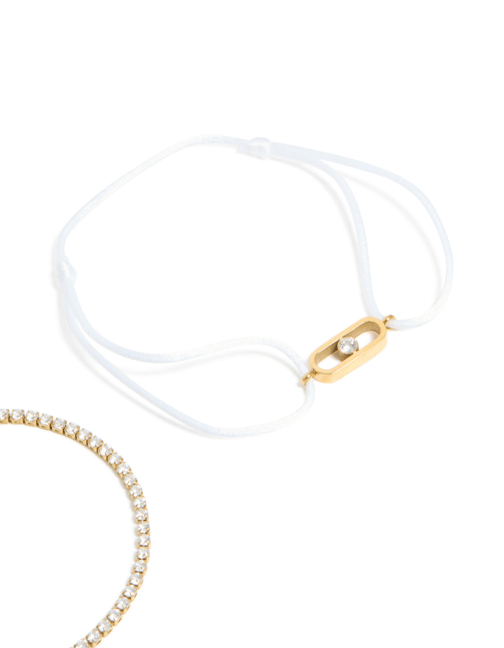 Beautiful waterproof gold plated stainless steel bracelet set with oval cut cubic zirconia tennis and white cord close up view