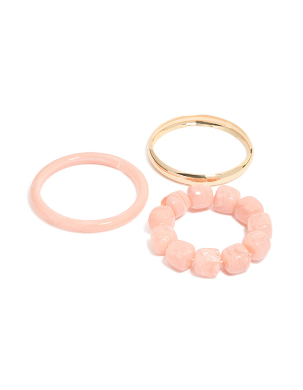Shop pink acrylic and gold smooth bangles 3-pack featuring beaded bracelet designs in front view