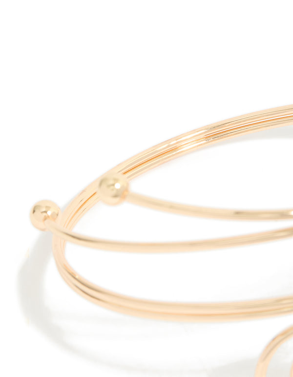 Featuring gold double swirl arm cuff with statement design in close up view