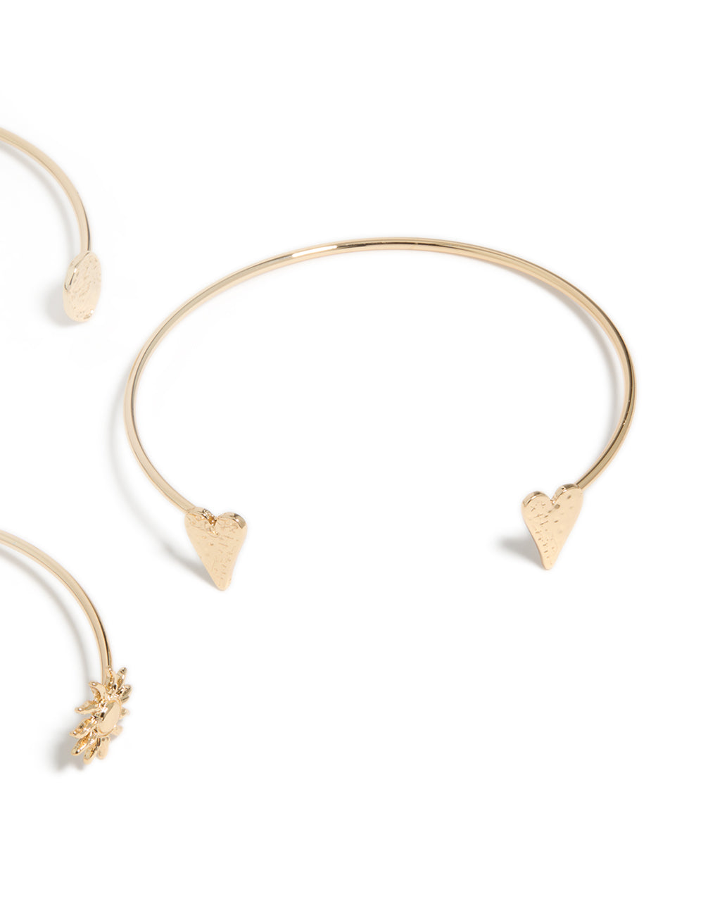 A close look at gold open mixed designed arm cuffs 3-pack with celestial and heart accents in close up view