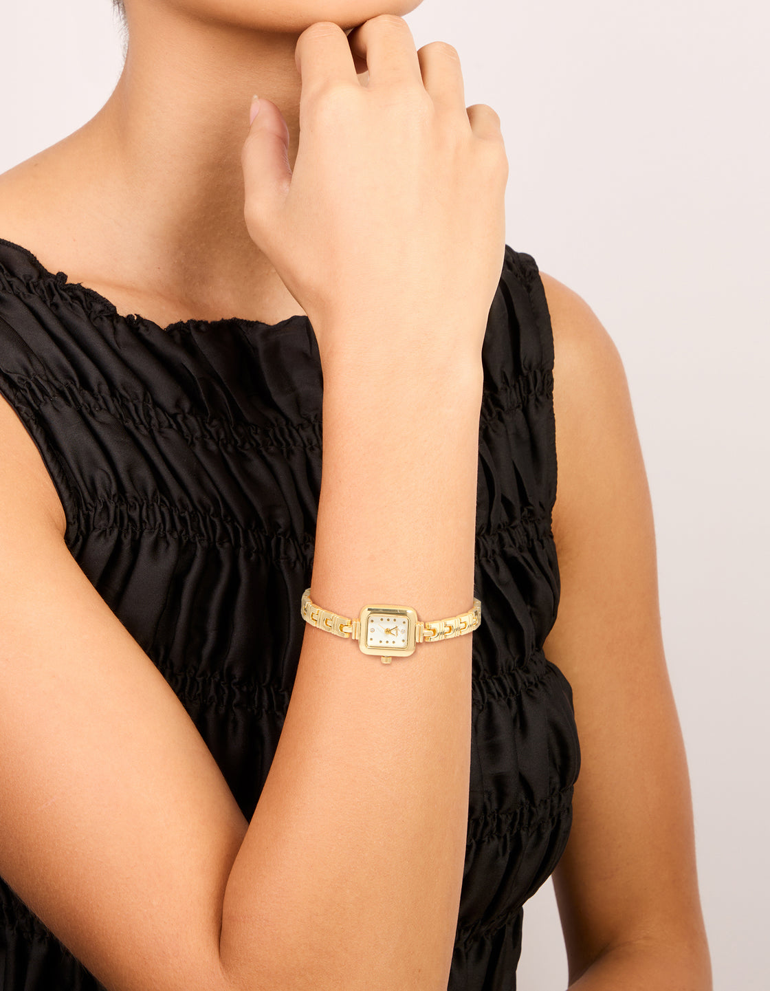Elegant gold Egyptian link mini watch featuring a white rectangle dial, crafted for women in a dainty casual analog style on wrist view