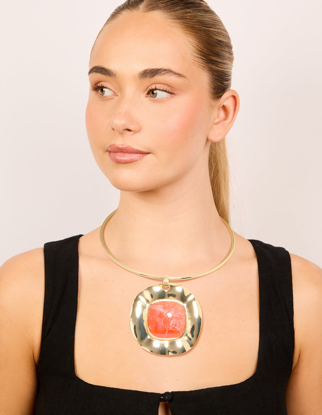 Displaying a gold orange pendant choker torque necklace with statement style on model view